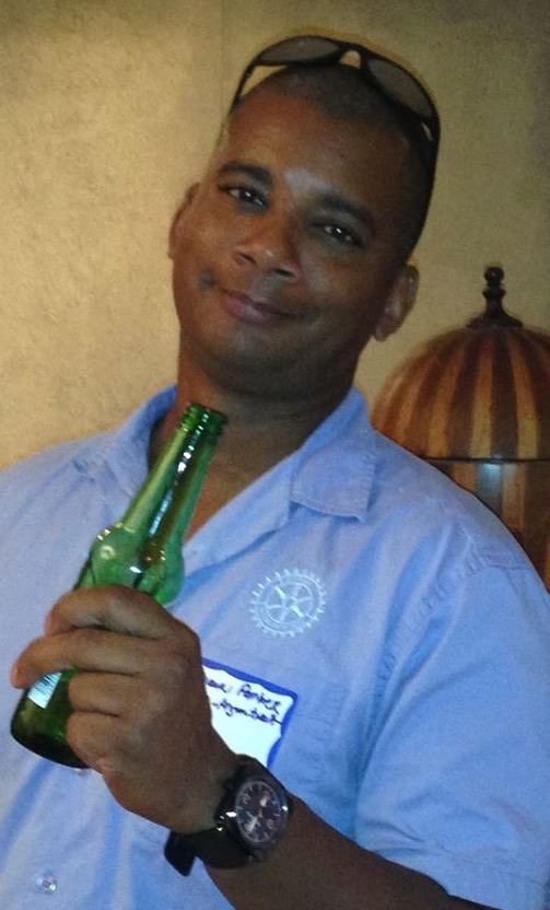 Shawn Parker smiling and holding a green bottle